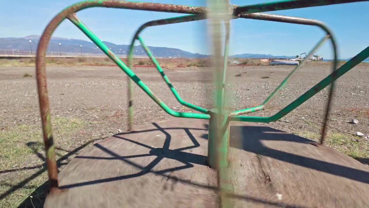 Old rusty Children's merry-go-round spinning on deserted holiday beach