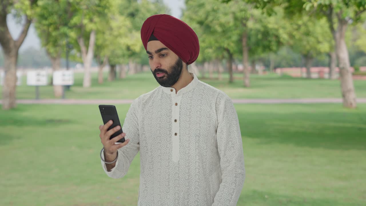 Uomo indiano Sikh arrabbiato che urla durante una videochiamata nel parco.