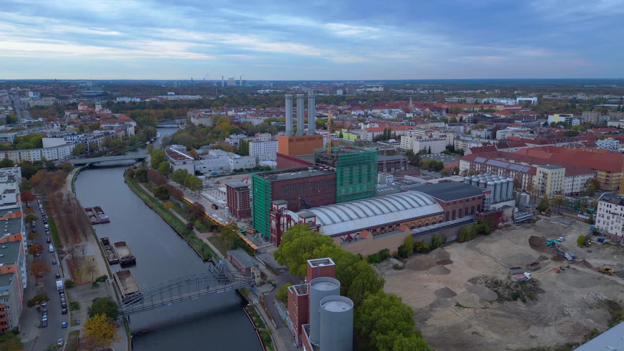 Combined heat and power plant operating in the cityscape by Spree river with new buildings under construction. Marvelous aerial view flight panorama overview drone