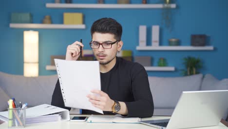 joven que trabaja en la oficina de casa leyendo malas noticias y enojándose.