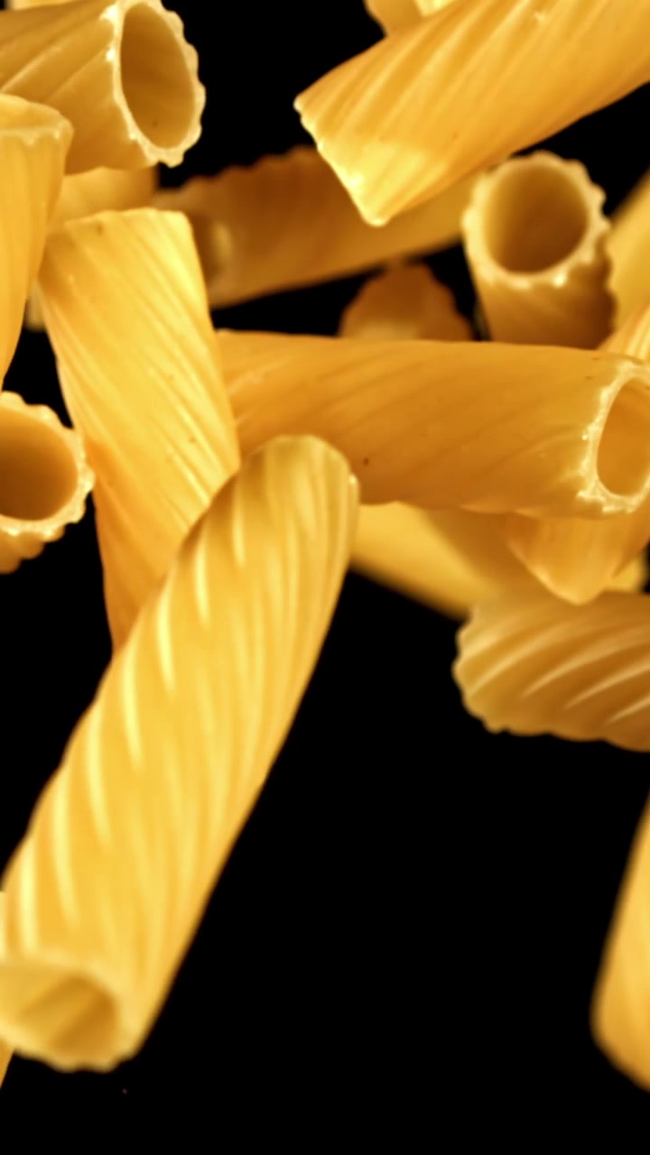 Pasta secca che cade al rallentatore su sfondo nero