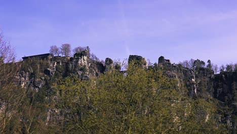 Simple-zoom-out-shot-of-the-Bastei-bridge-hills-at-Elbe-Valley,-the-view-from-inside-the-train,-Basteibrücke,-rathen,-Germany