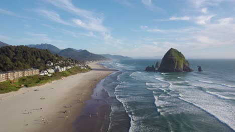 Cannon-Beach-Con-El-Famoso-Hito-De-La-Roca-Pajar-En-La-Costa-Oeste-De-Oregon,-Estableciendo-Una-Antena-Inclinada-Hacia-Arriba