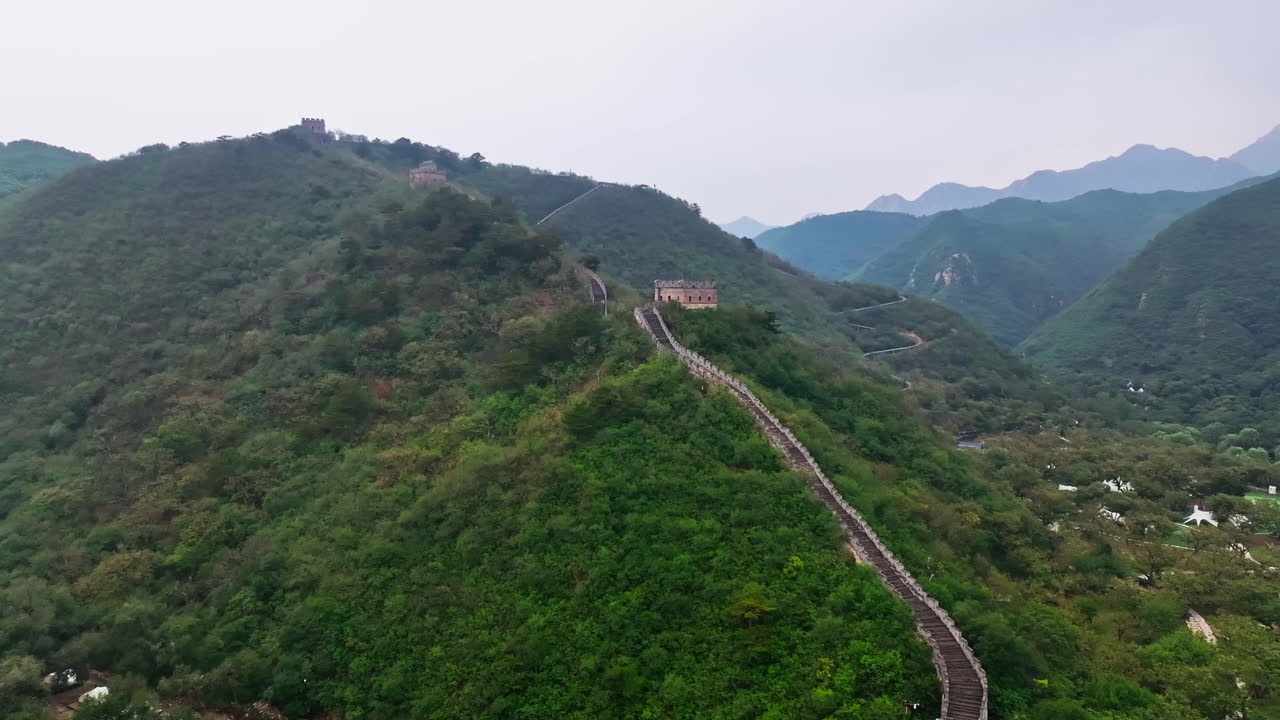 Aerial view following the Great Wall uphill, dark, cloudy day in north China