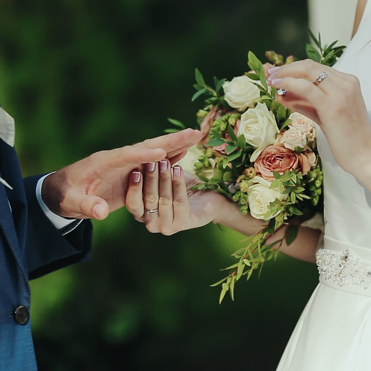 Newlyweds exchange rings at the wedding ceremony over green grass background. Wedding rings. Square video