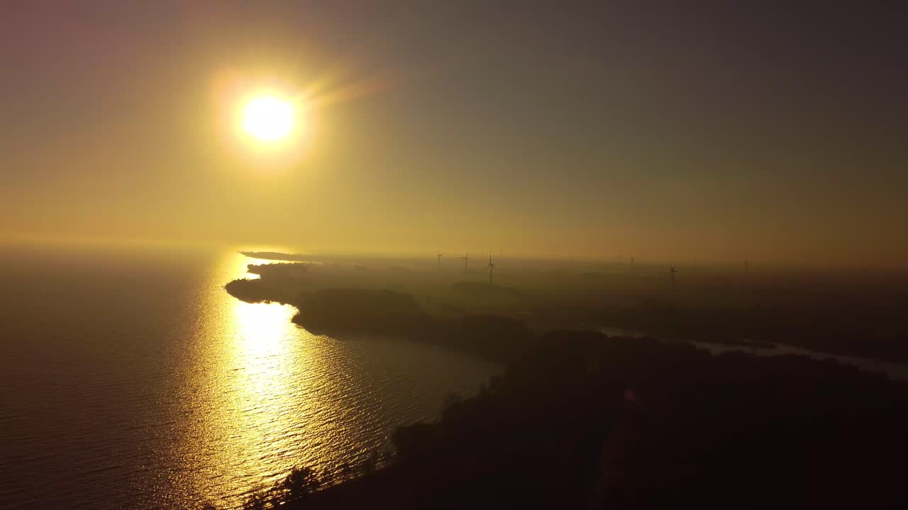 Yellow sunflare sunburst seaside with windmills electricity wind generators