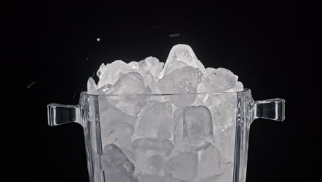 ice cubes fall into a glass ice container. slow motion 4k video.