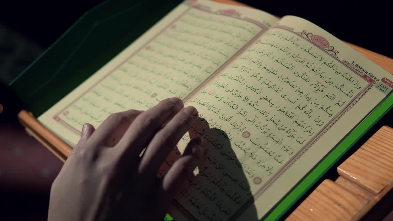 Giovane uomo musulmano che tiene il Corano in moschea
