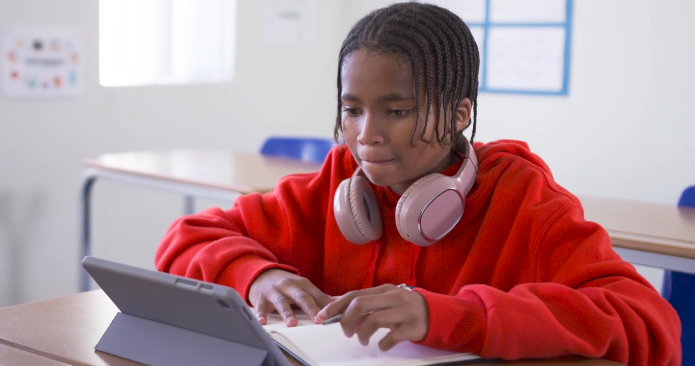 Tablet screen drawing focus, African American teen tapping and writing notes studying in class