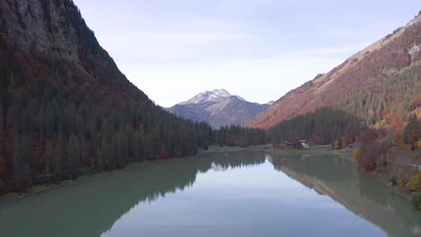 Hermosa-Toma-Aérea-Sobre-El-Lago-Montriond-Con-Una-Vista-Reflejada-De-Los-Alpes-Franceses-En-El-Fondo