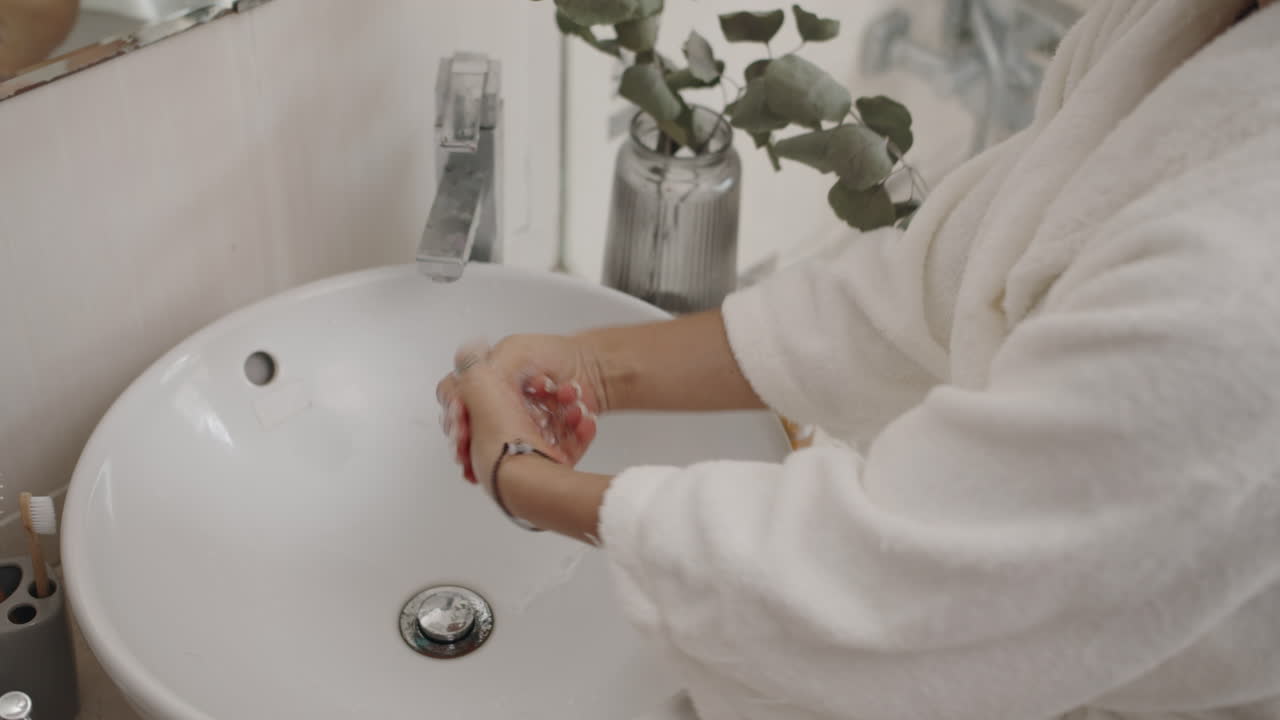 Unrecognizable Woman Rinsing Hands of Soap
