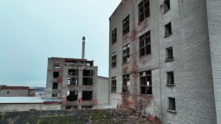 Industrial zone premises being ruined with time. Old buildings with broken windows ready to be demolished.