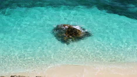 static footage from above of a rock in the ocean on exuma in the bahamas