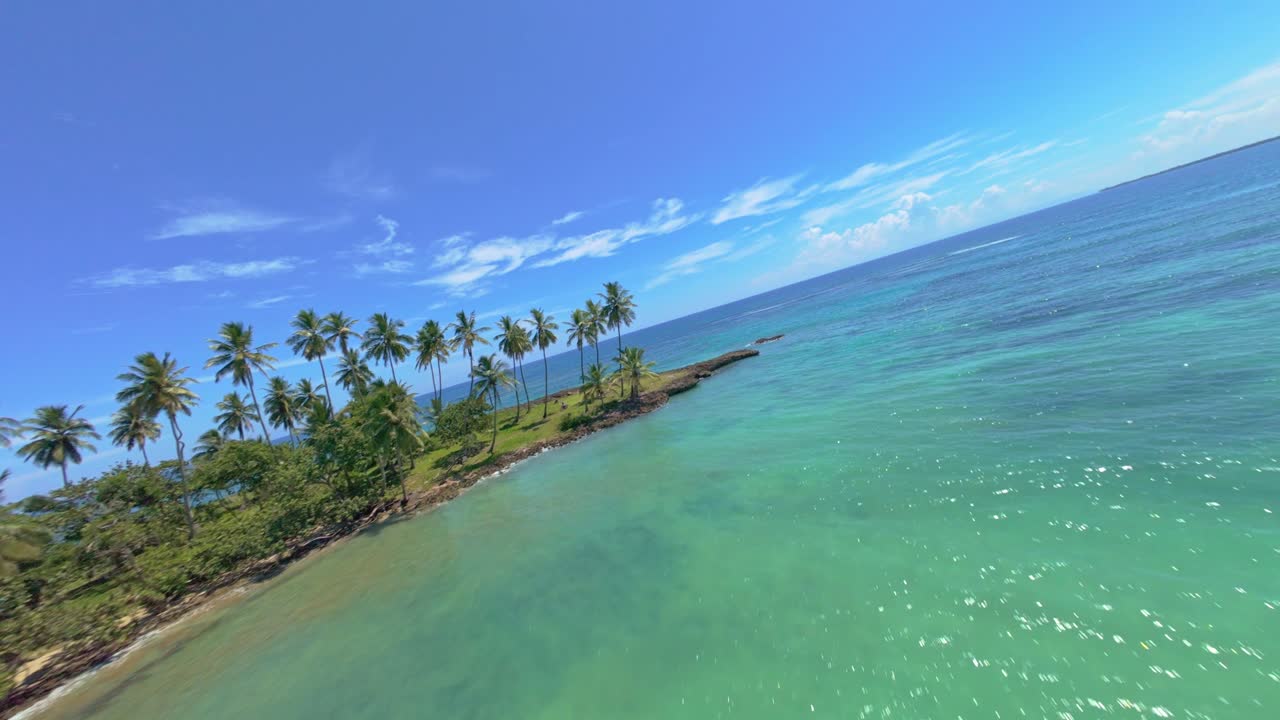 Ripresa con drone FPV che vola lungo la spiaggia di Playa los Coquitos, nei Caraibi soleggiati.