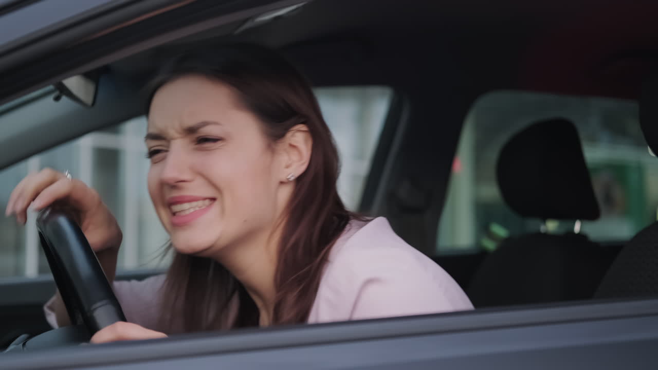 mujer conduciendo un coche que muestra signos de estrés o frustración