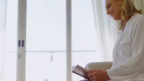 Disabled-woman-reading-a-book-in-bedroom-4k