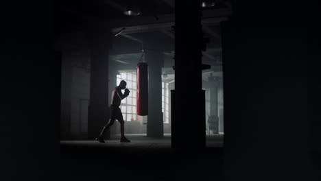 athlete performing physical exercises. afro man doing boxing training in gym