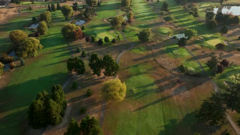 Vista-De-Arriba-Hacia-Abajo-De-Un-Campo-De-Golf-A-Primera-Hora-De-La-Mañana-Con-Parches-De-Hierba-Muerta-Del-Calor-Del-Verano