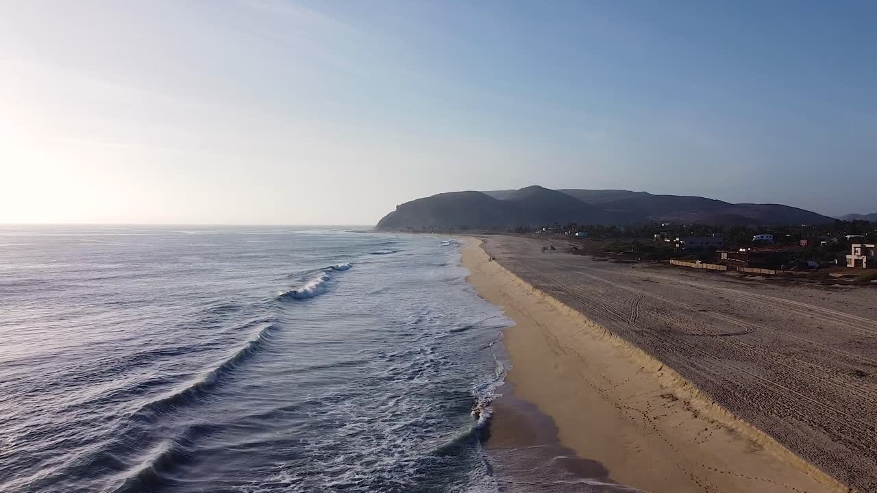 casas de lujo frente al mar a lo largo de la arena de la ciudad costera del océano pacífico con olas que chocan contra la playa