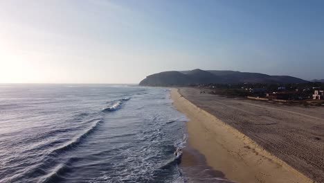 Luxuriöse-Häuser-Am-Wasser-Entlang-Einer-Sandigen-Küstenstadt-Am-Pazifik-Mit-Wellen,-Die-Gegen-Den-Strand-Krachen