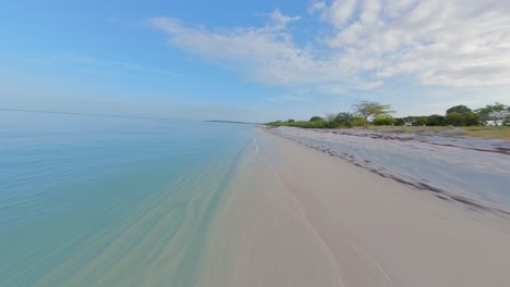 Vuelo-Rápido-Sobre-Una-Playa-De-Arena-De-República-Dominicana-A-Lo-Largo-Del-Claro-Mar-Caribe