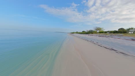 velocidad de vuelo sobre la playa de arena de la república dominicana a lo largo del claro mar del caribe