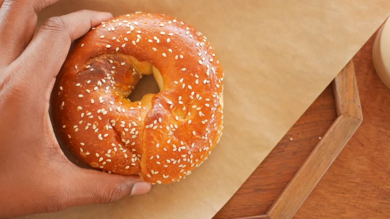 Hand holding a sesame seed bagel
