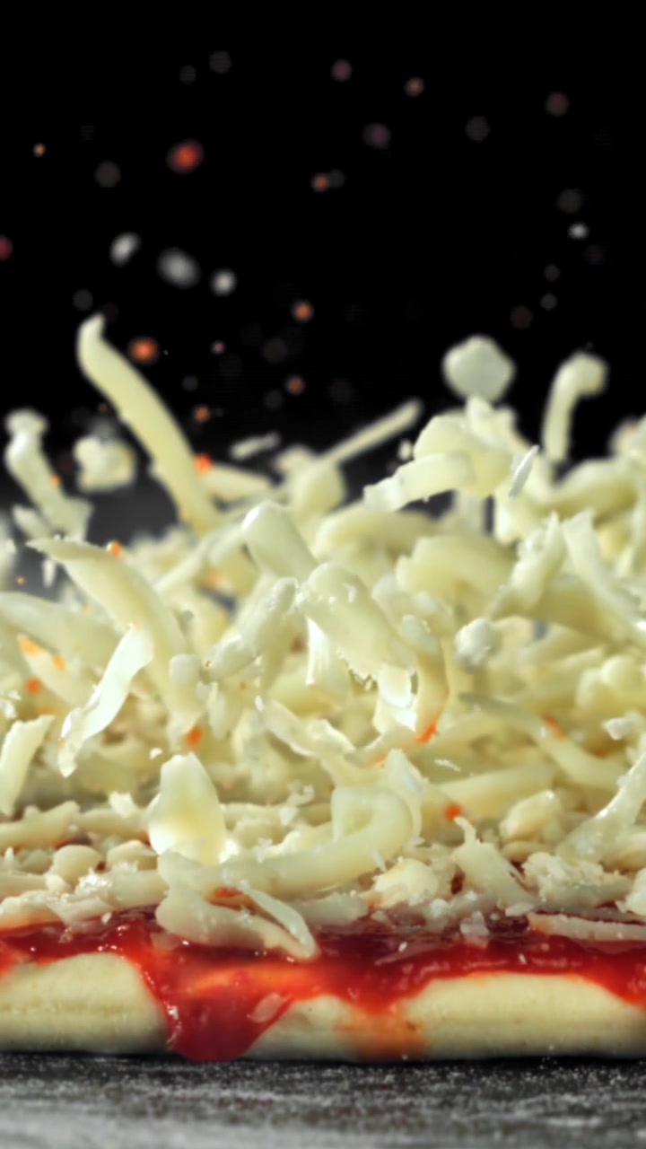 Revet Mozzarella-ost faller ned på pizzabunn i sakte film