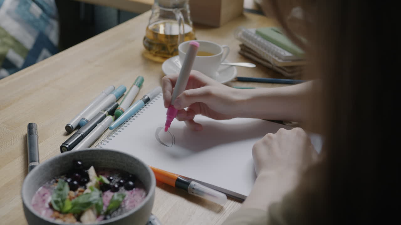 Woman Drawing in a Cafe