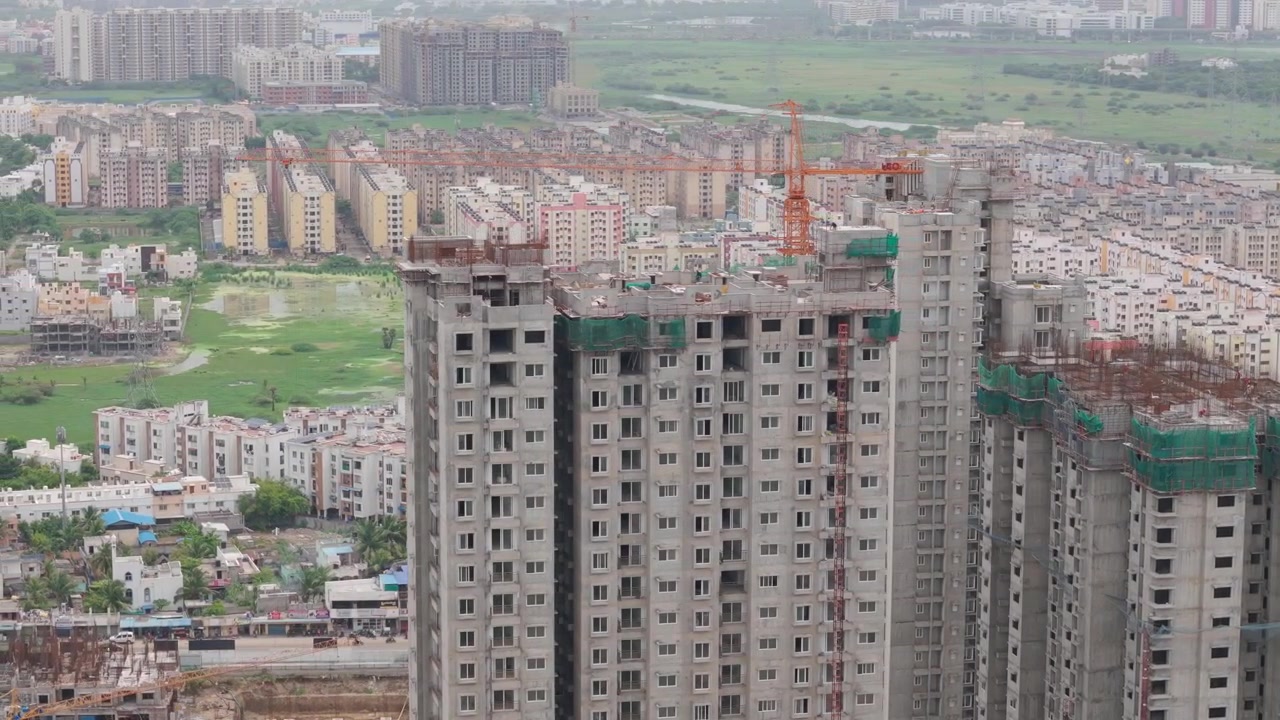 Các tòa tháp chưa hoàn thiện mọc lên cùng cần cẩu khi máy bay không người lái bay lượn phía trên đường chân trời dày đặc của Chennai