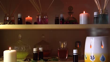 perfume making room with lots of candles flasks and glasses with colored liquids, near a steamer with steam coming out, and dust flying around