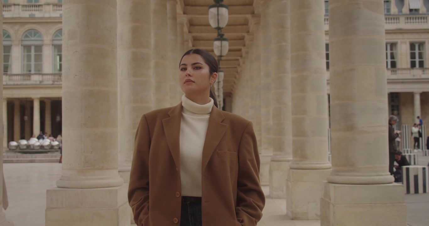 Una donna cammina lungo i colonnati in un palazzo storico a Parigi, Francia. Rallentatore.