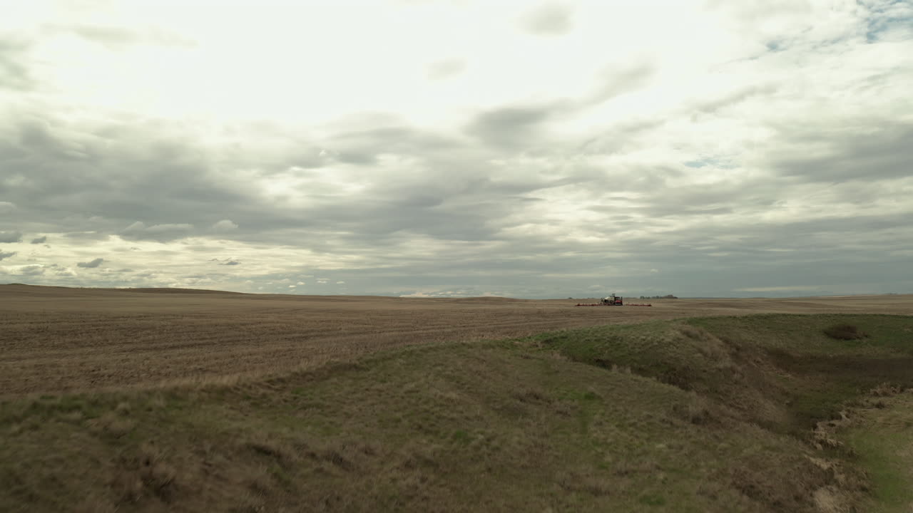 Flyvende over marken med en landbrugstraktor, der sår i Saskatchewan, Canada