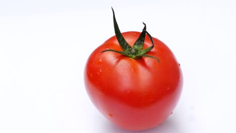 el tomate gira sobre un fondo blanco.