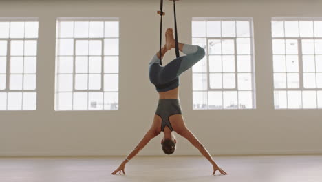 healthy aerial yoga woman practicing hanging upside down using hammock enjoying fitness lifestyle exercising in studio training meditation at sunrise