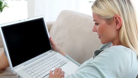 una mujer rubia usando una computadora portátil