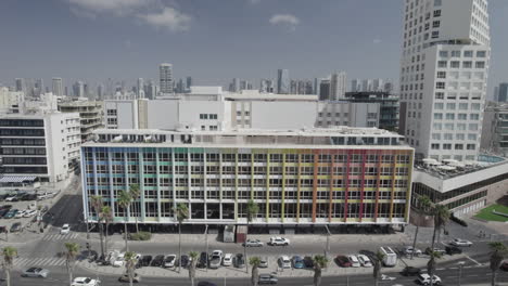 the colorful dan hotel in tel aviv, rainbow building on the gordon promenade and frishman beach full of visitors on a warm and calm summer day