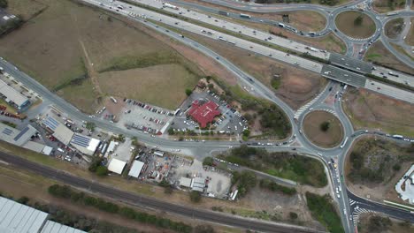 Vista-Desde-Arriba-De-Los-Transportes-Que-Navegan-Por-La-Autopista-Del-Pacífico-En-El-Suburbio-De-Yatala,-Gold-Coast,-Queensland