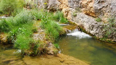 Gesperrte-Aufnahme-Eines-Kleinen-Flusses,-Der-Eine-Schlucht-Hinunterfließt