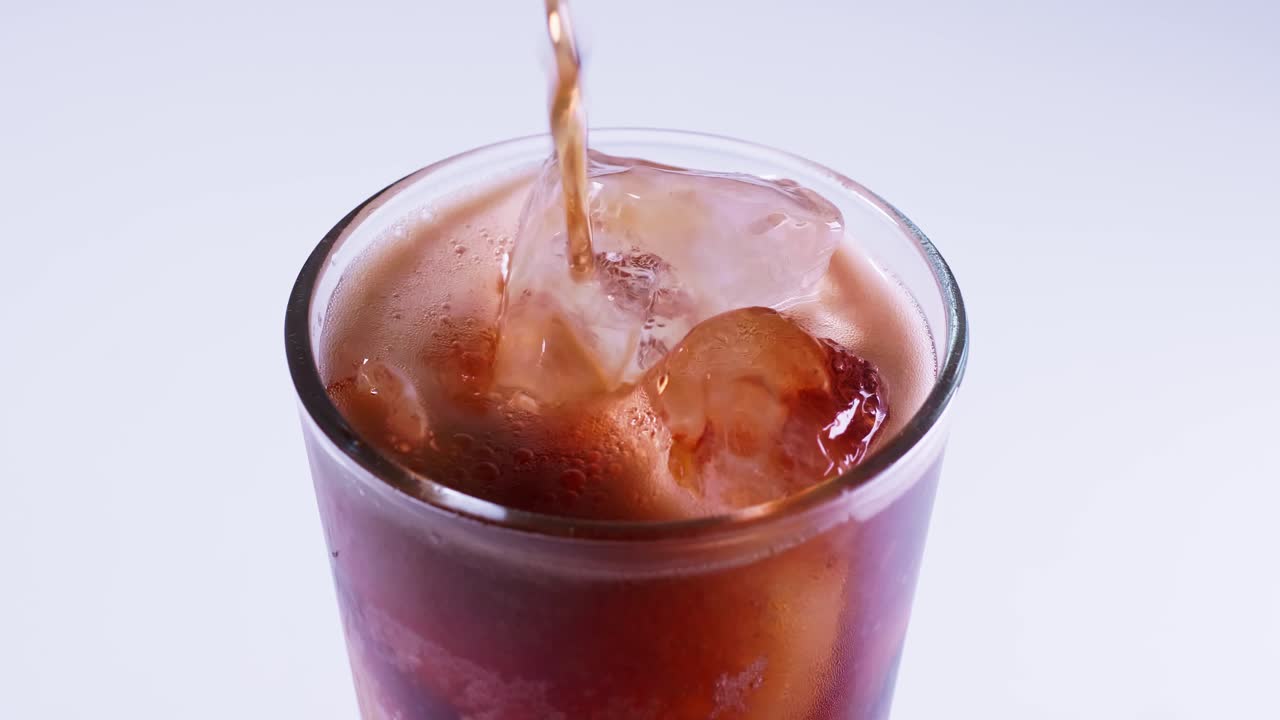 la coca cola se vierte en un vaso de una botella