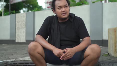 man sitting and talking on the street
