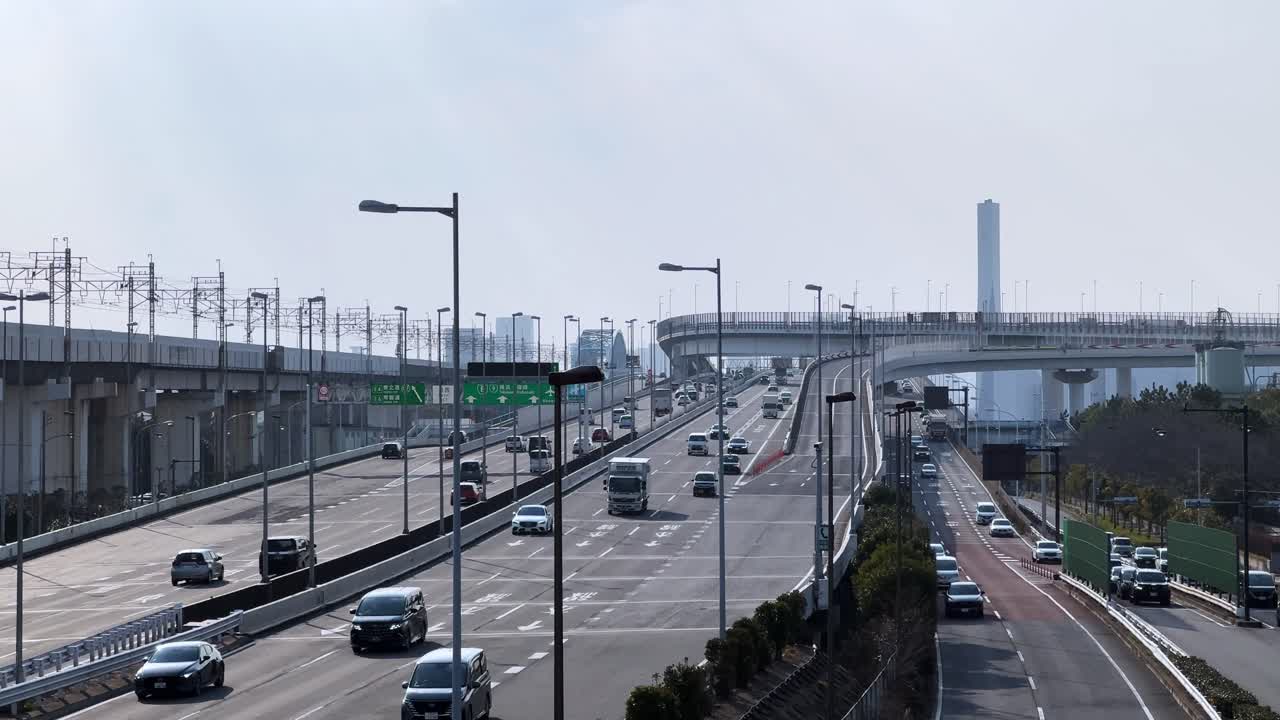Wide aerial view of highways and roads with cars, towers, and bridges in Tokyo, Japan