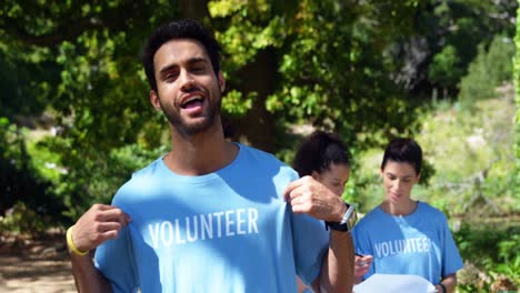 smiling volunteer pointing at his t-shirt 4k