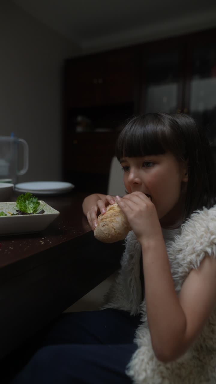 Girl Eating Bread at Dinner Table