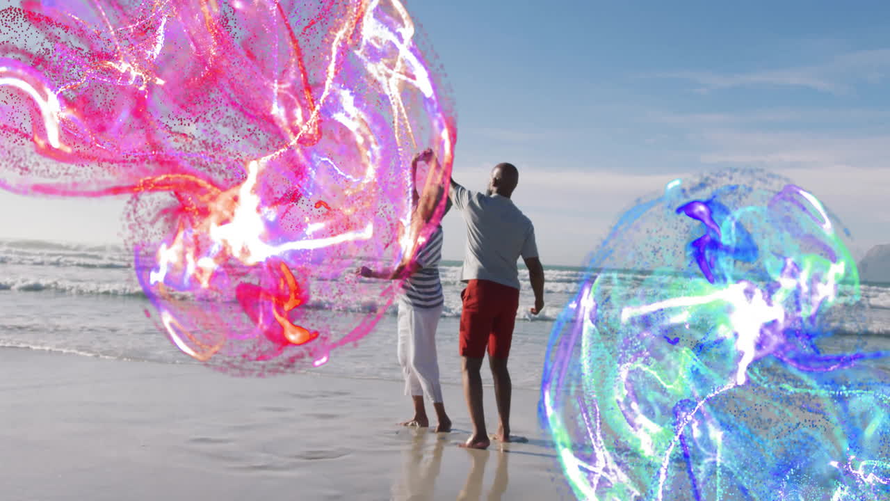 Hombre haciendo equilibrio en una tabla de skimboard con una mujer en la orilla, mostrando tecnología con remolinos de partículas