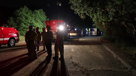 los bomberos se paran alrededor del camión de bomberos