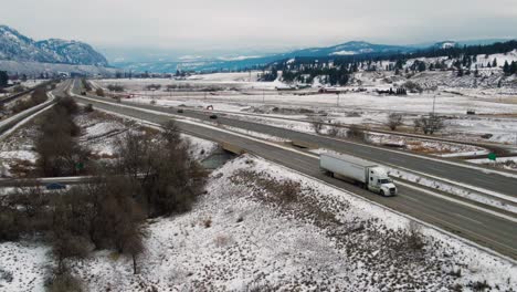 vista aérea de los viajes de invierno: automóviles y semirremolques navegando por la autopista 1 entre kamloops y chase en un día nublado