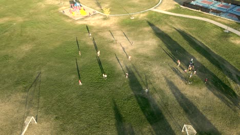 Kinder-Spielen-Kickball-Im-Park---Umlaufende-Luftaufnahme
