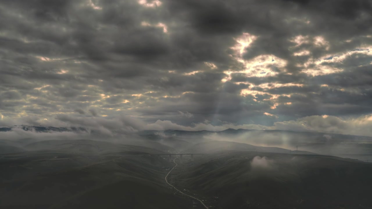 Aerial View of Rolling Hills and Valley Under Dramatic Cloudy Sky