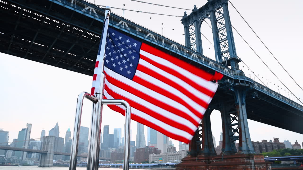 Bandiera americana che sventola sulla parte anteriore della barca. Angolazione dal basso sul Manhattan Bridge